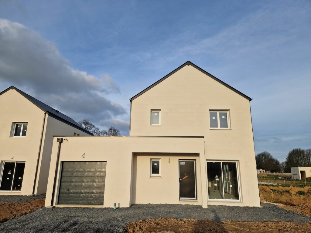 Photo du devant d'une maison neuve avec porche et garage par le constructeur Maisons Caen Construction